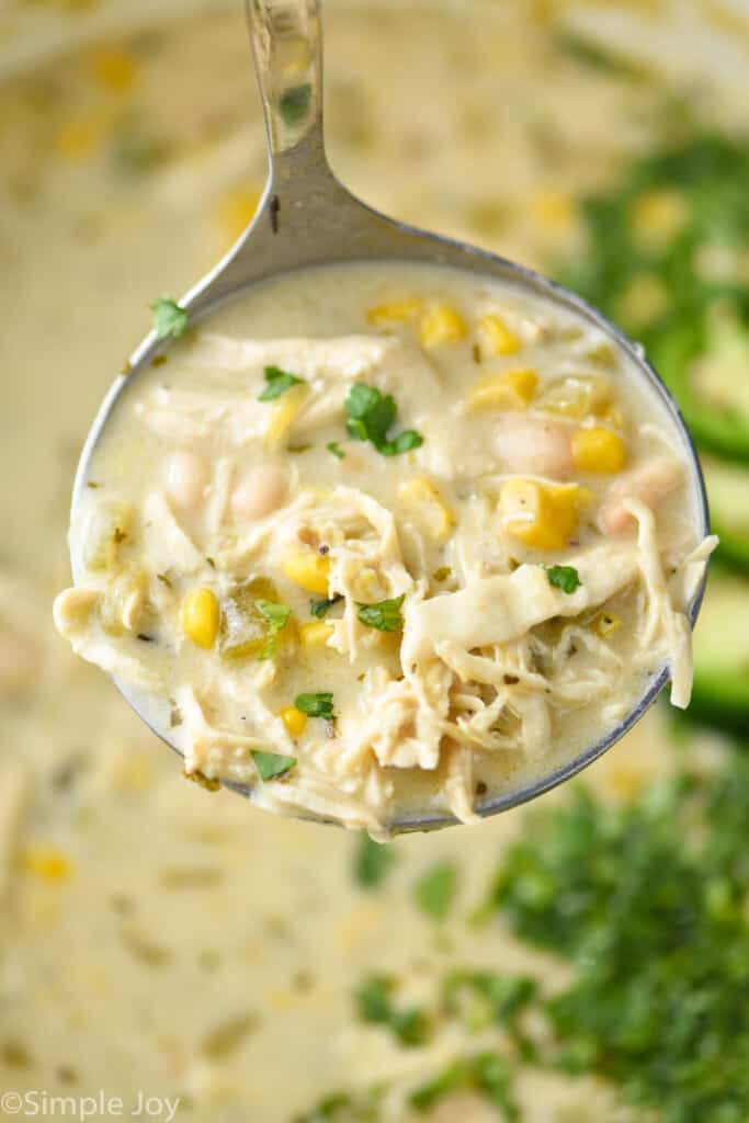 close up of a ladle of creamy white chicken chili