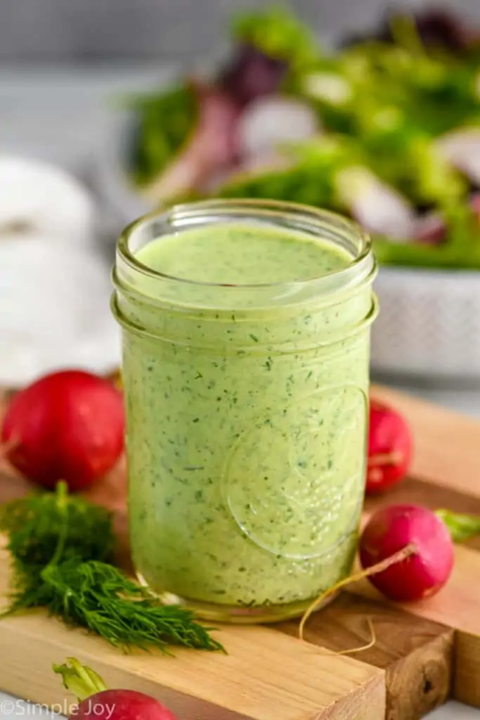 side view of a mason jar full of green goddess dressing recipe