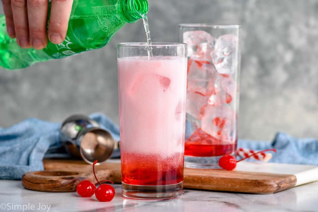 pouring sprite over grenadine to make a Shirley Temple