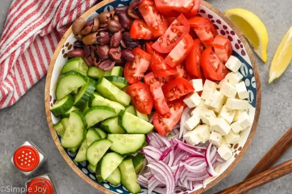 overhead of mediterranean cucumber salad broken up by ingredient