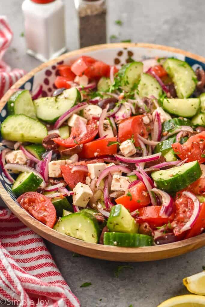 side view of a overhead view of Mediterranean salad recipe in a wooden bowl