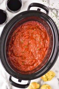 overhead of a slow cooker with crockpot spaghetti sauce recipe in it
