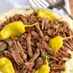 pinterest graphic of a Mississippi pot roast shredded and over mashed potatoes with fresh pepperoncinis on top