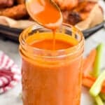 spoon dripping buffalo sauce into a mason jar full of it