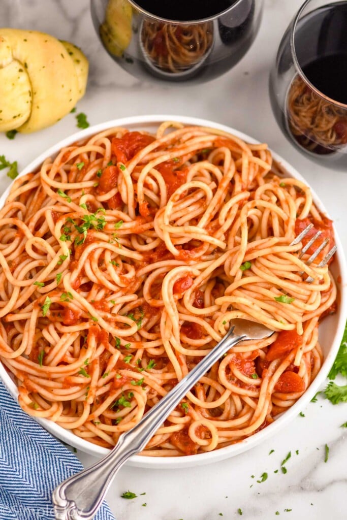 overhead of a plate of spaghetti with sauce mixed in to it