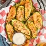 overhead of a basket full of baked jalapeno poppers next to ranch dressing