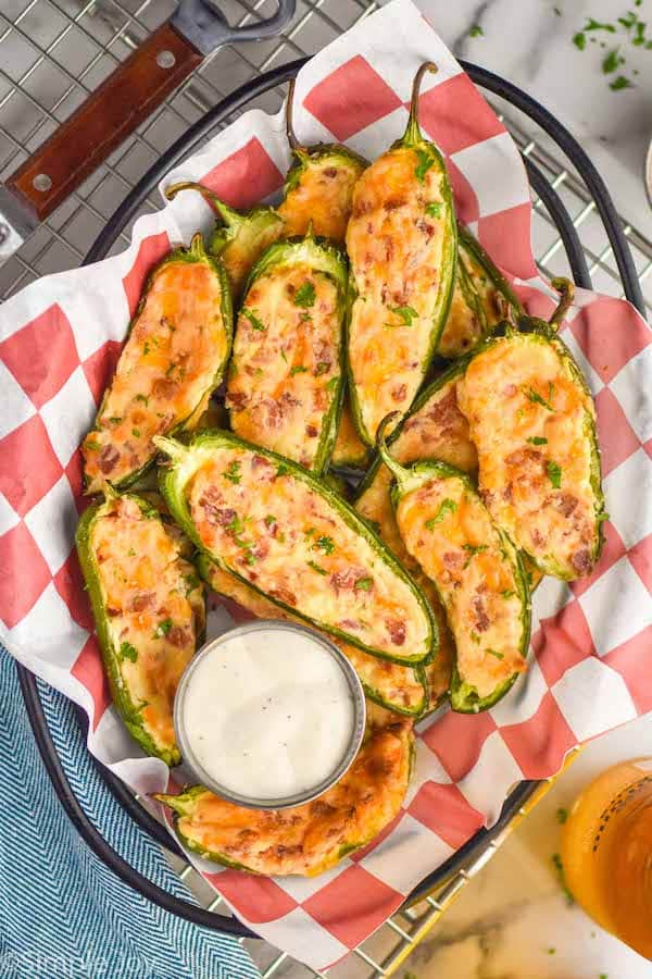 overhead of a basket full of baked jalapeno poppers next to ranch dressing