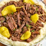 a Mississippi pot roast shredded and over mashed potatoes with fresh pepperoncinis on top - 10