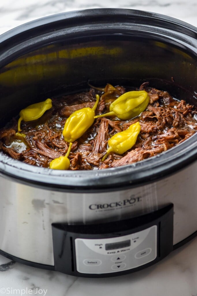 a Mississippi pot roast in a crock pot after being cooked and shredded