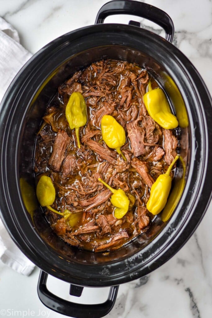 overhead of a Mississippi pot roast in a crock pot after being cooked and shredded