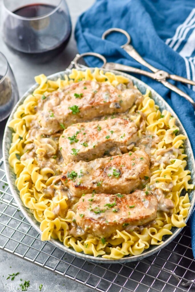 four pork chops in a creamy mushroom sauce on a bed of egg noodles