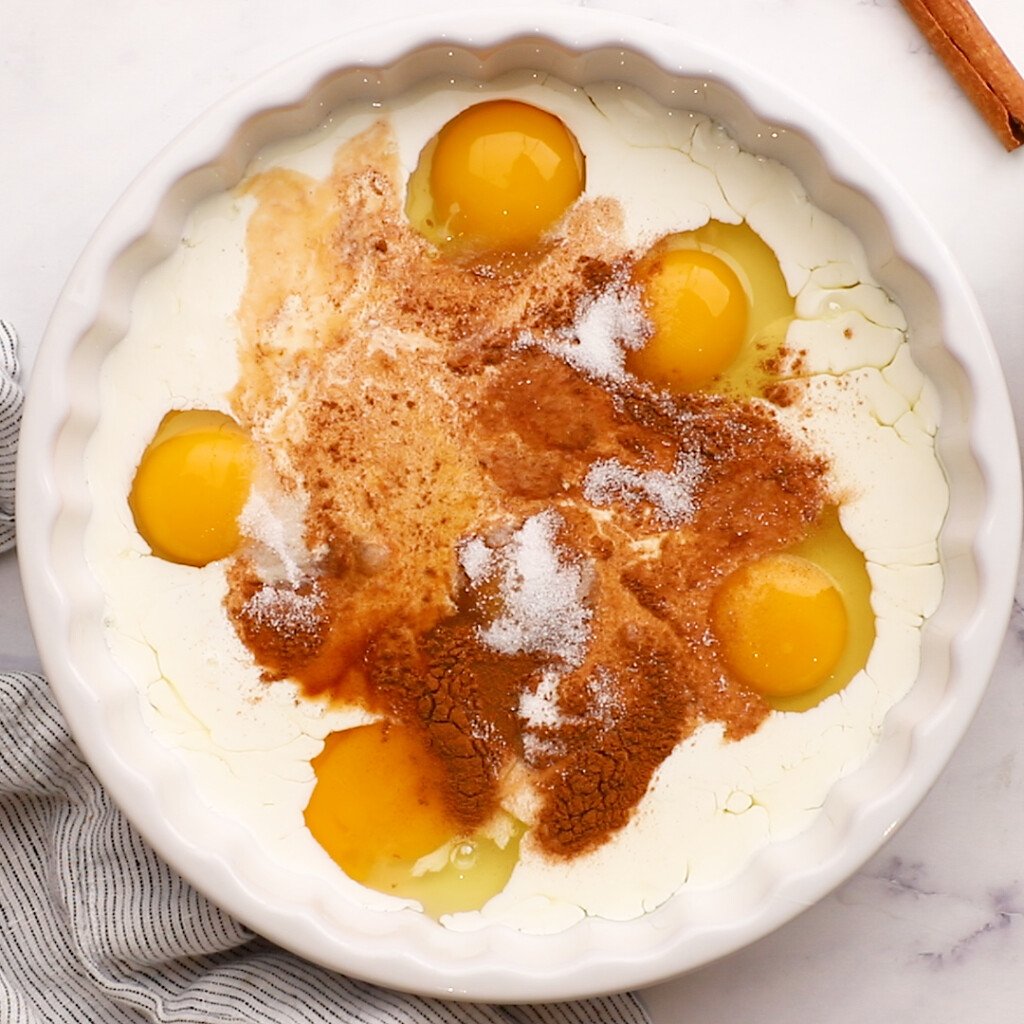a pie plate with half and half, eggs, vanilla, and cinnamon