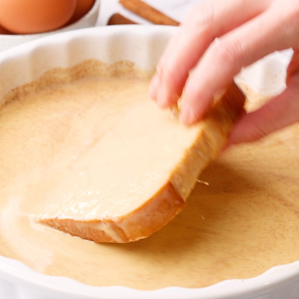 bread being flipped in batter to make French toast