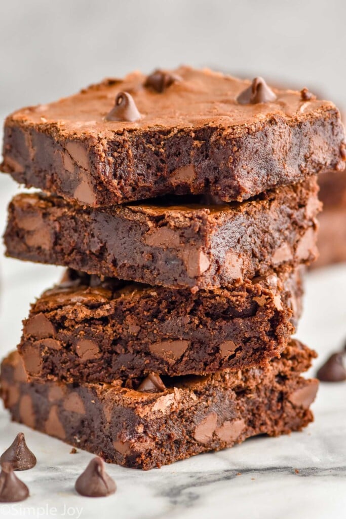 a stack of four chocolate brownies with the top one missing a bite