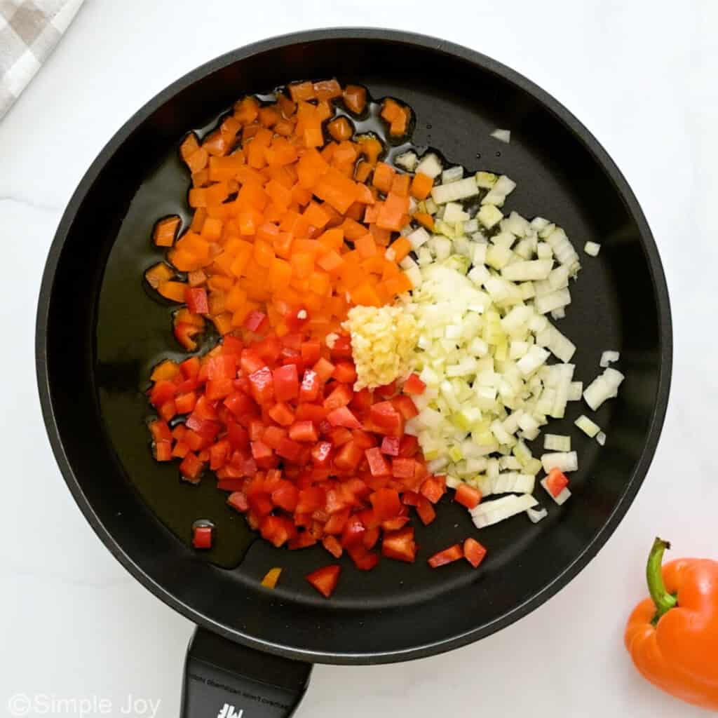 overhead of vegetables being sautéed in a frying pan