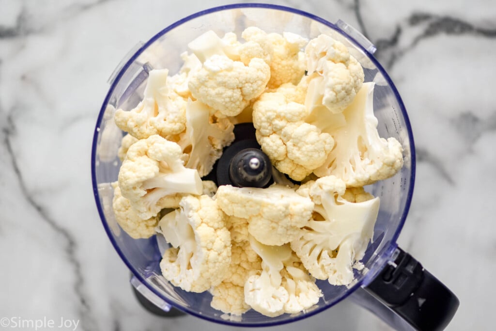 overhead of cauliflower florets in a food processor