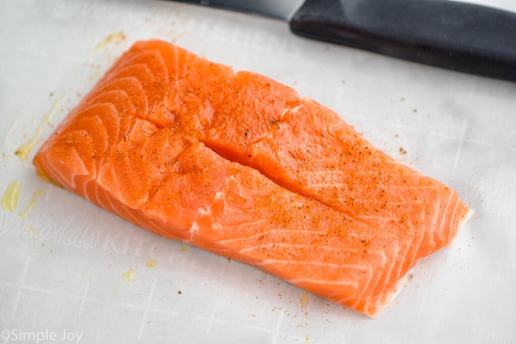 a piece of raw salmon with a slit down the middle for stuffing