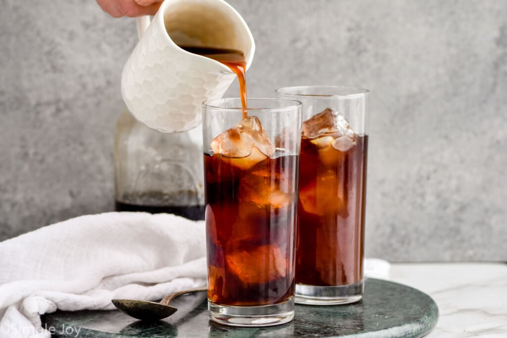 pouring Irish cream syrup into cold brew coffee