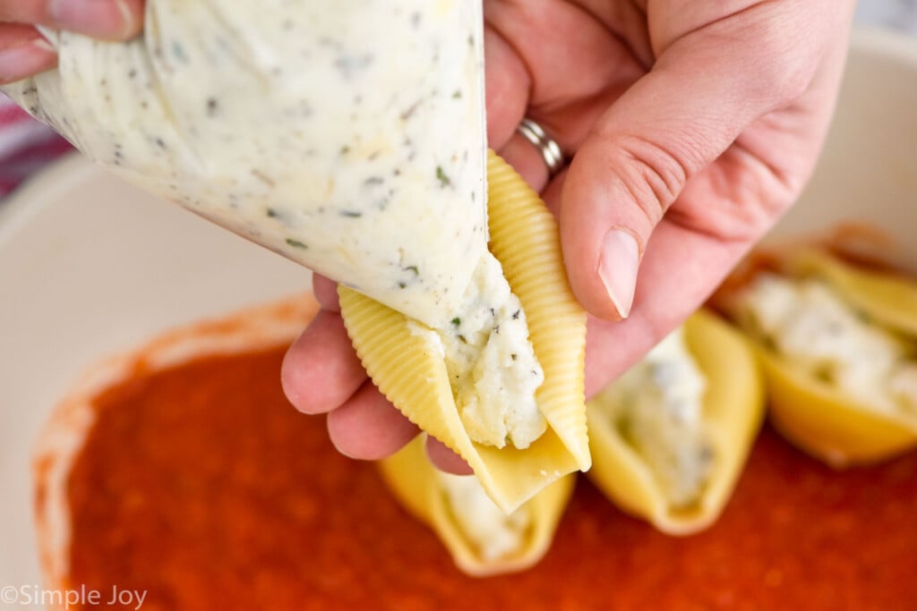 close up of cheese filling in a ziplock bag being piped into a jumbo pasta shell