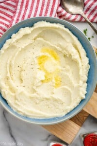 overhead of a bowl of mashed cauliflower with butter melting on it