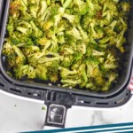 pinterest graphic of overhead of an air fryer basket with cooked broccoli in it