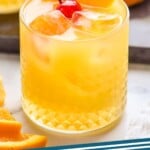 pinterest graphic of amaretto stone sour in a tumbler with ice, an orange slice, and a cherry