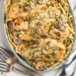 pinterest graphic of overhead of creamy mushroom chicken on a platter on a bed of linguine