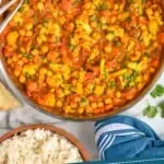 pinterest graphic overhead view of a skillet with vegetable curry and two serving forks
