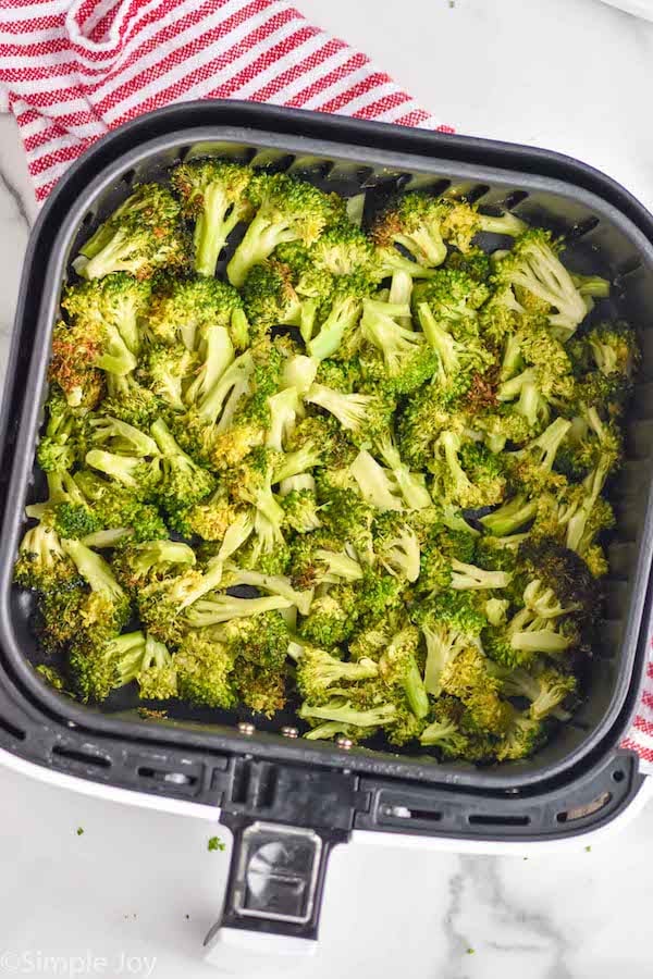 overhead of an air fryer basket with cooked broccoli in it