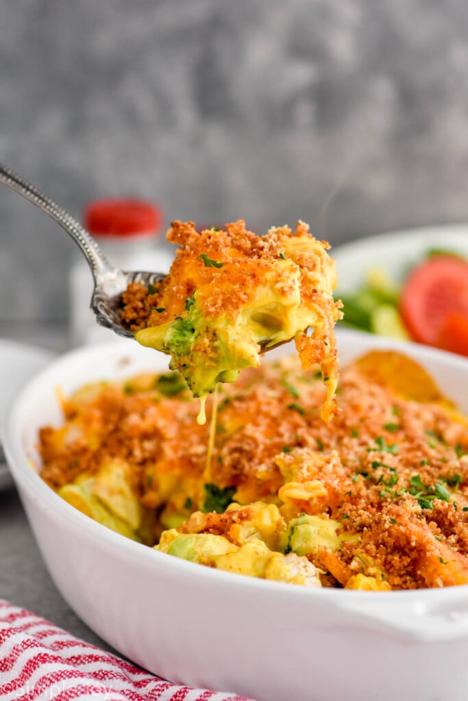 chicken divan with curry being scooped out of a casserole dish with a serving spoon