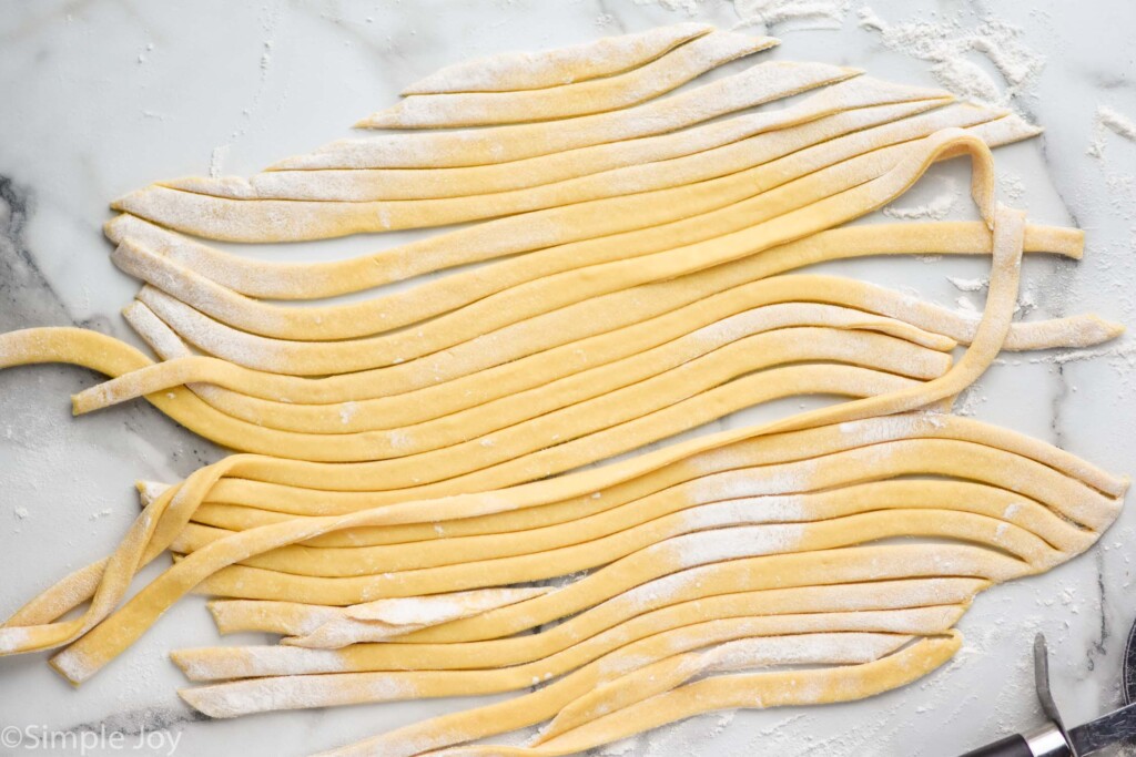 overhead view of egg noodle dough that has been cut into strips