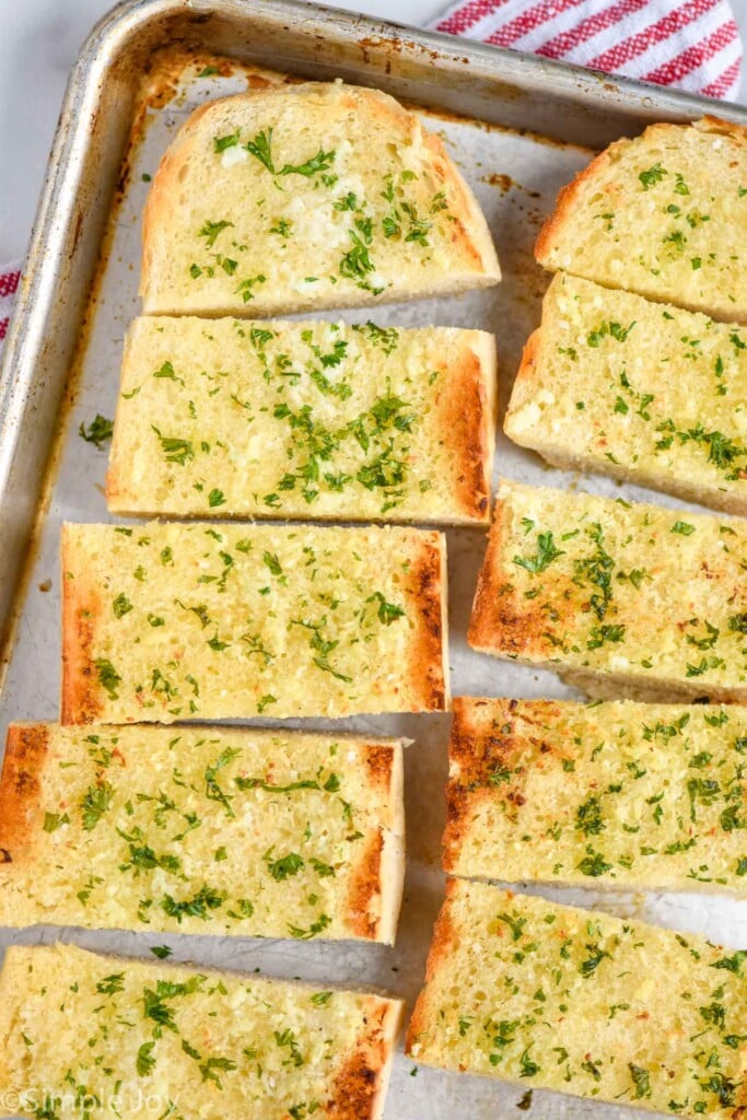 cut up best garlic bread recipe on a rimmed baking sheet