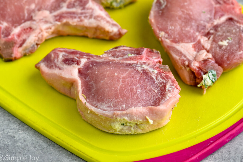 side view of a pork chop on a cutting board with stuffing in it