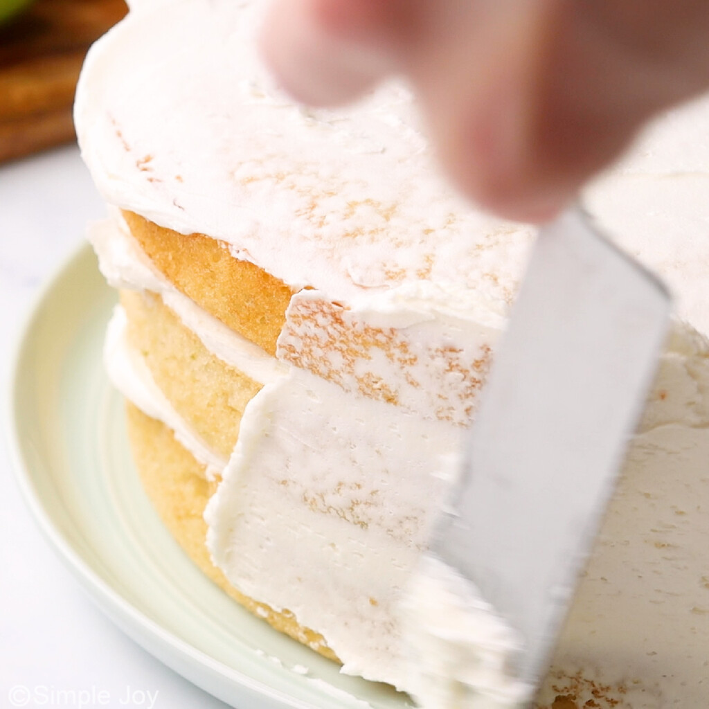 adding a crumb coat to the outside of a three layer cake