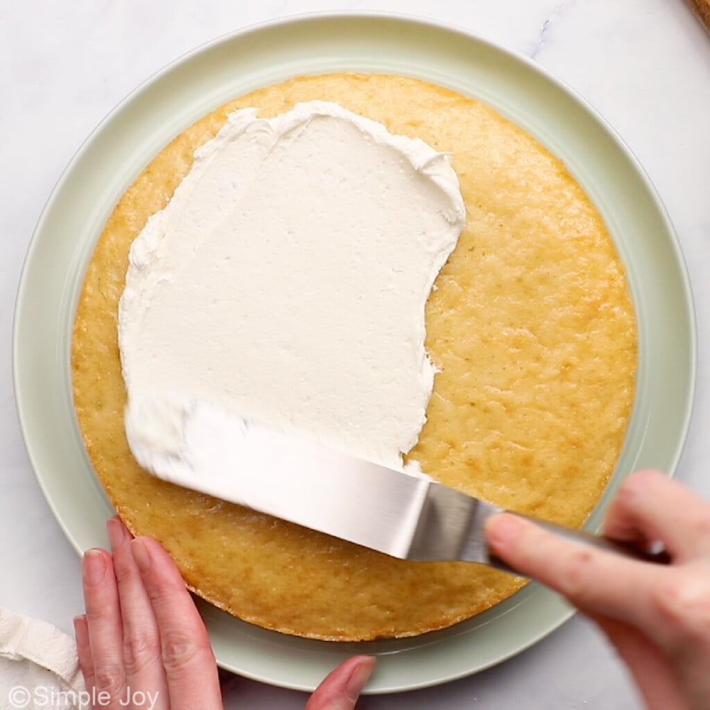 adding frosting to the top of a cake round