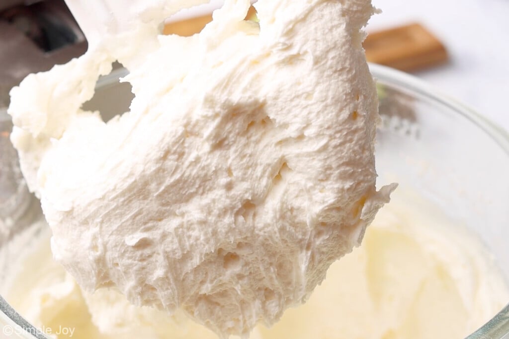 fluffy key lime frosting on the paddle attachment of a mixer