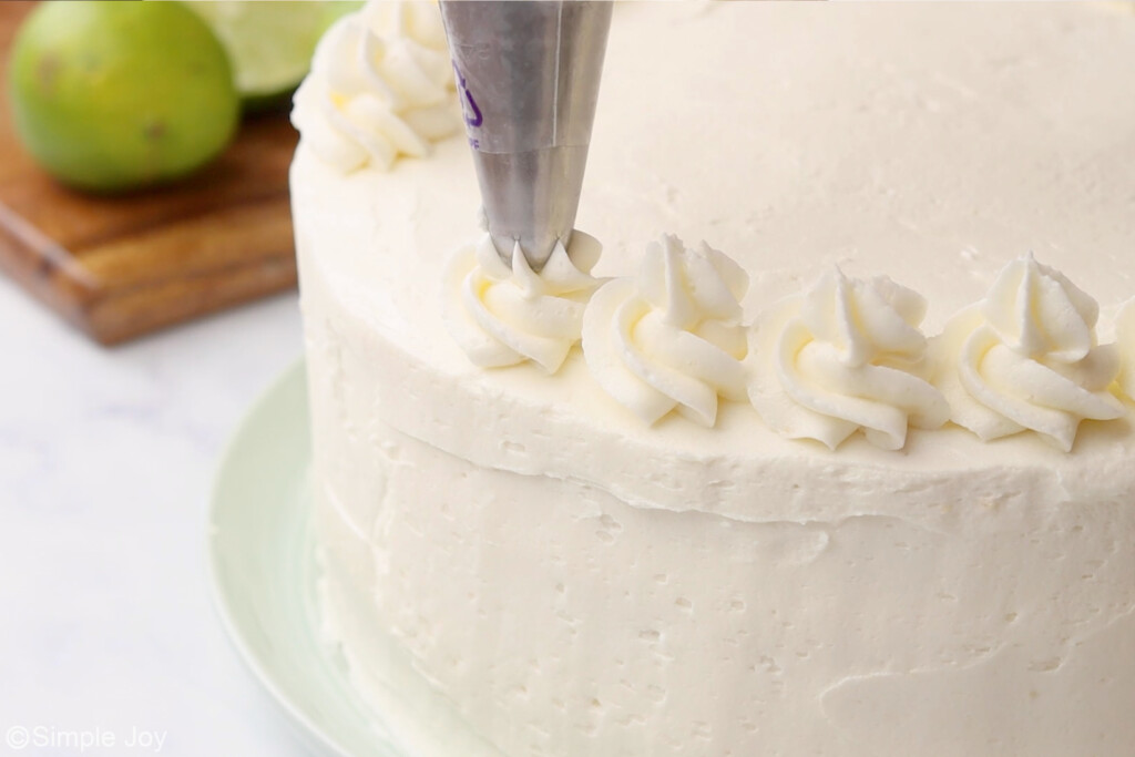 piping swirls on top of a three layer cake