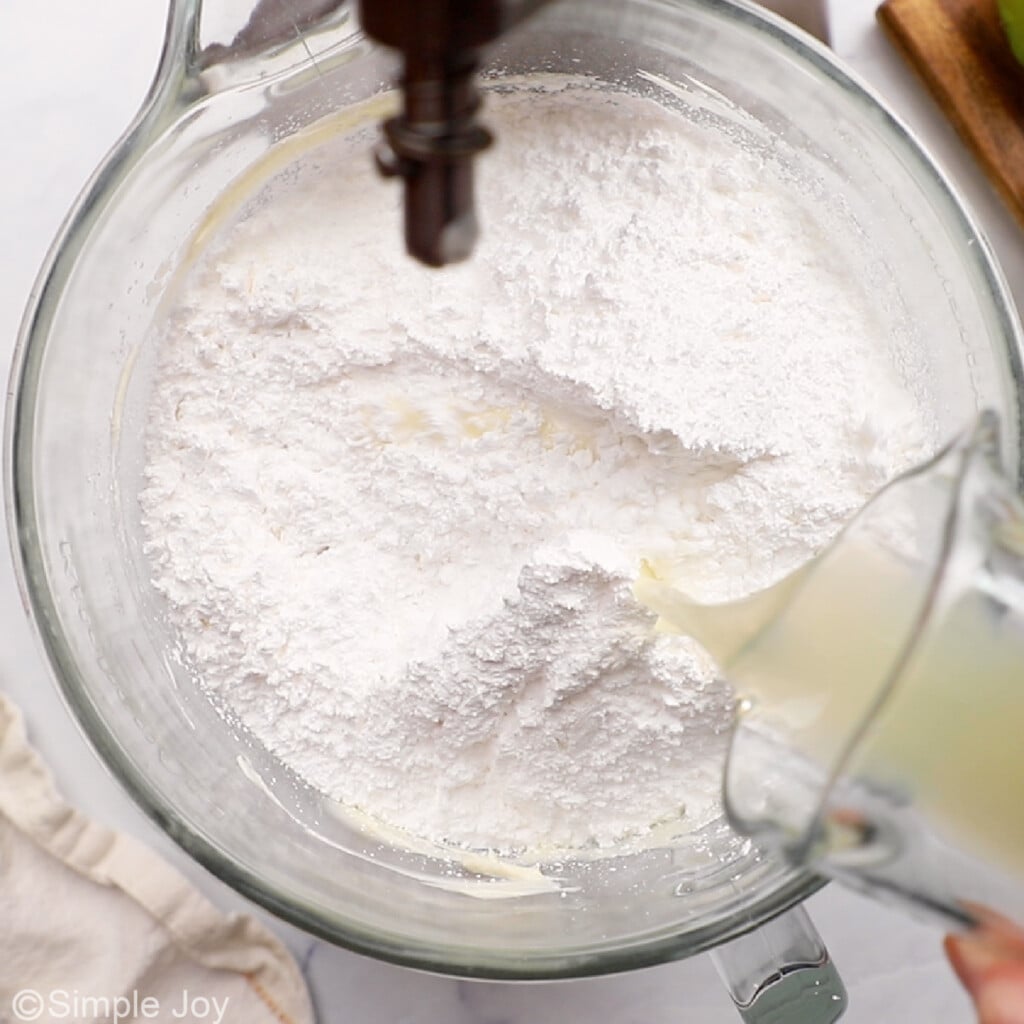 powdered sugar and key lime juice being added to the bowl of a stand mixer
