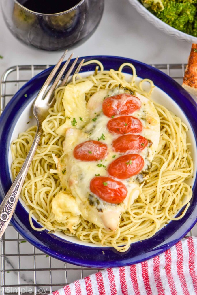 pesto chicken recipe on top of a bed of angel hair pasta