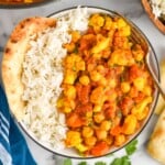 overhead of a bowl of vegetable curry with rice in it and naan - 10