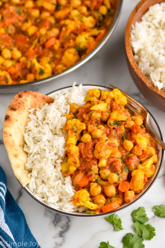 side view of a bowl of vegetarian curry recipe with rice and naan