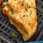 Pinterest graphic of air fryer chicken breast recipe. Overhead photo of air fryer chicken breasts in air fryer basket. Text says, "Air Fryer Chicken Breasts simplejoy.com"