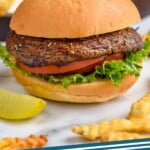 pinterest graphic of portobello burger on a bun with lettuce and tomato and fries next to it