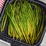 overhead photo of air fryer asparagus in the basket of an air fryer