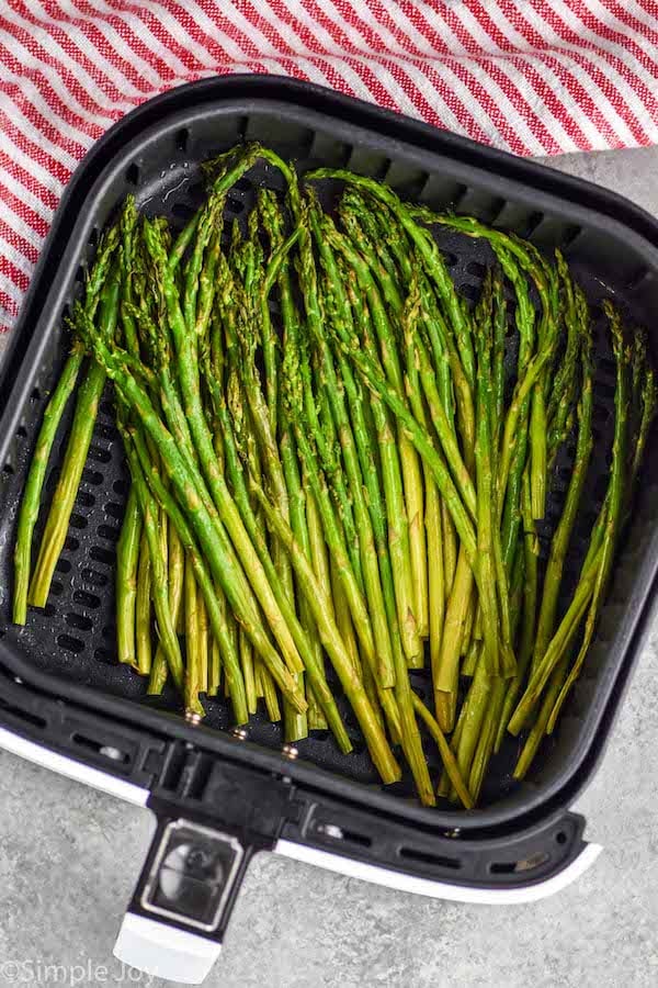 overhead photo of air fryer asparagus in the basket of an air fryer
