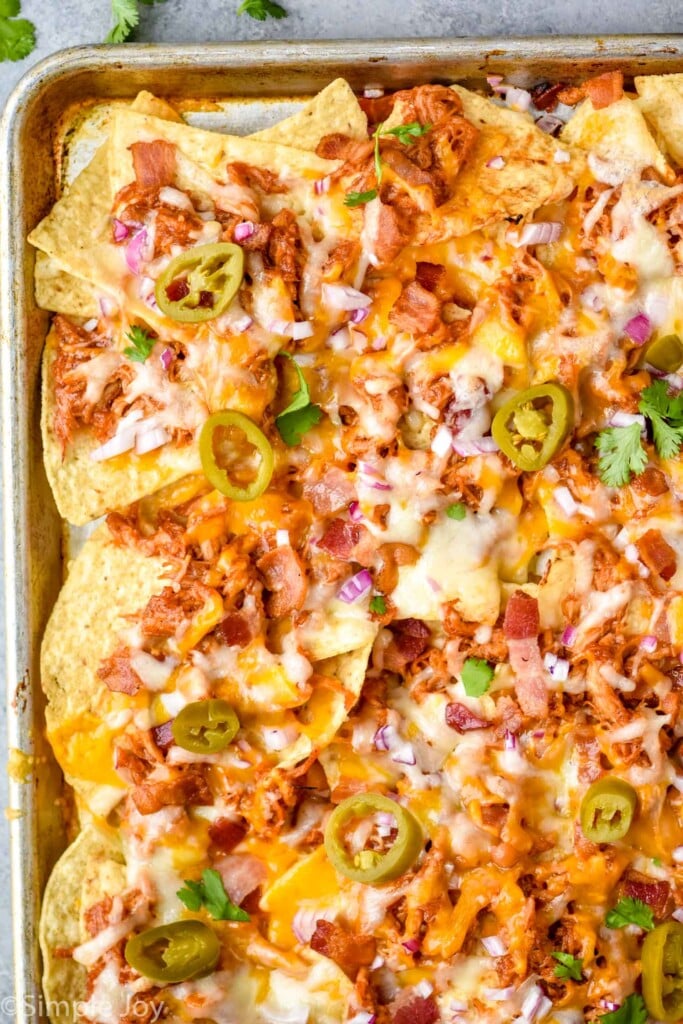 overhead of bbq chicken nachos recipe in a rimmed baking sheet