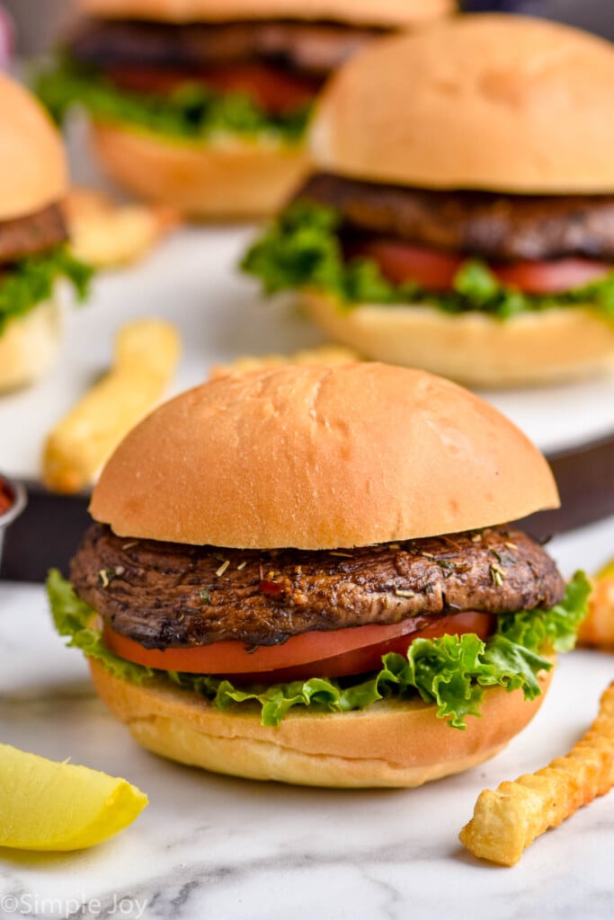 portobello burger on a bun with lettuce and tomato and fries next to it