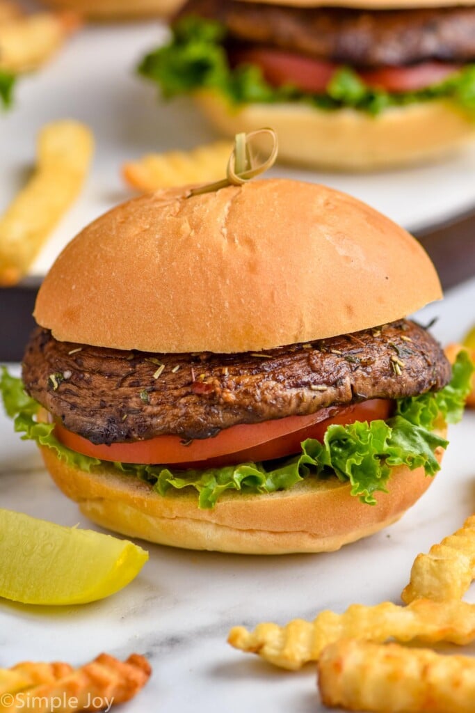 portobello burger on a bun with lettuce and tomato and fries next to it