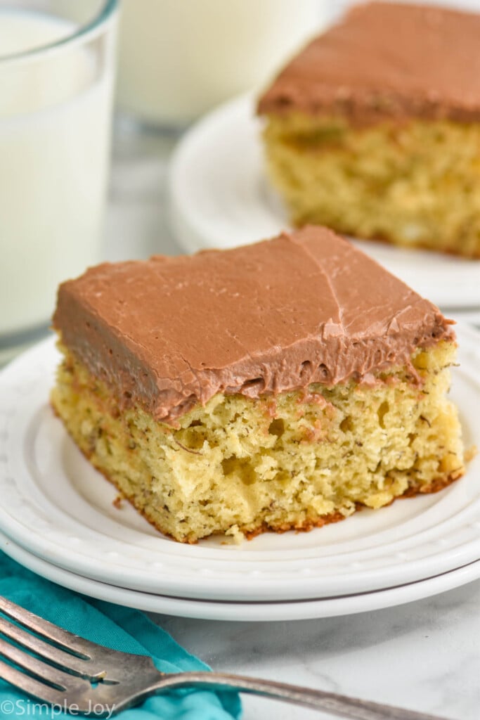 piece of banana cake with chocolate frosting on a white plate