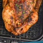 Pinterest graphic of air fryer whole chicken recipe. Overhead photo of air fryer whole chicken in air fryer basket. Text says, "super easy air fryer chicken simplejoy.com"